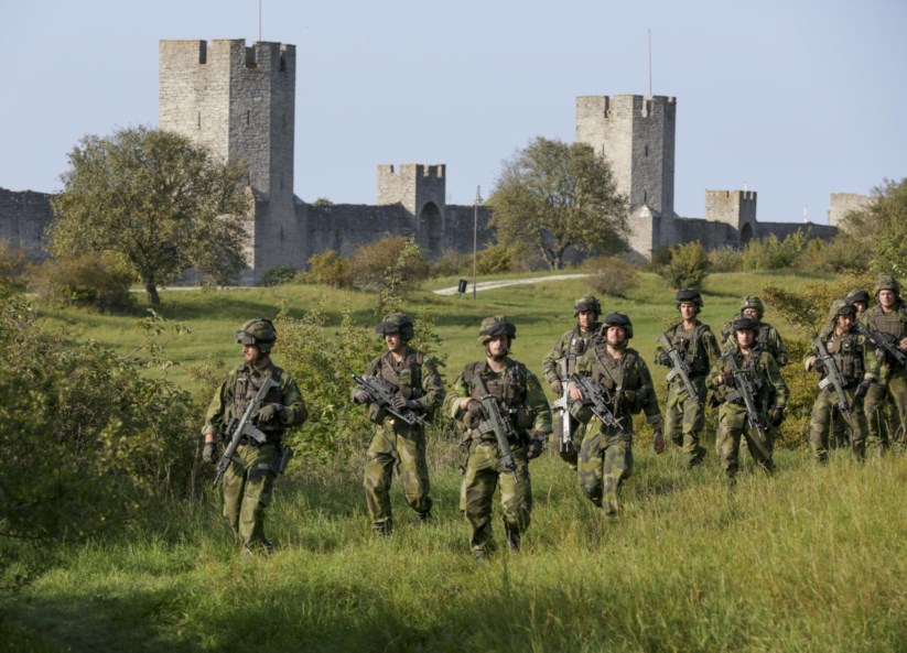 Militares suecos junto às muralhas medievais da cidade de Visby, na Gotlândia