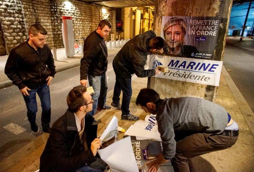 Jovens da Frente Nacional colando cartazes em Lyon