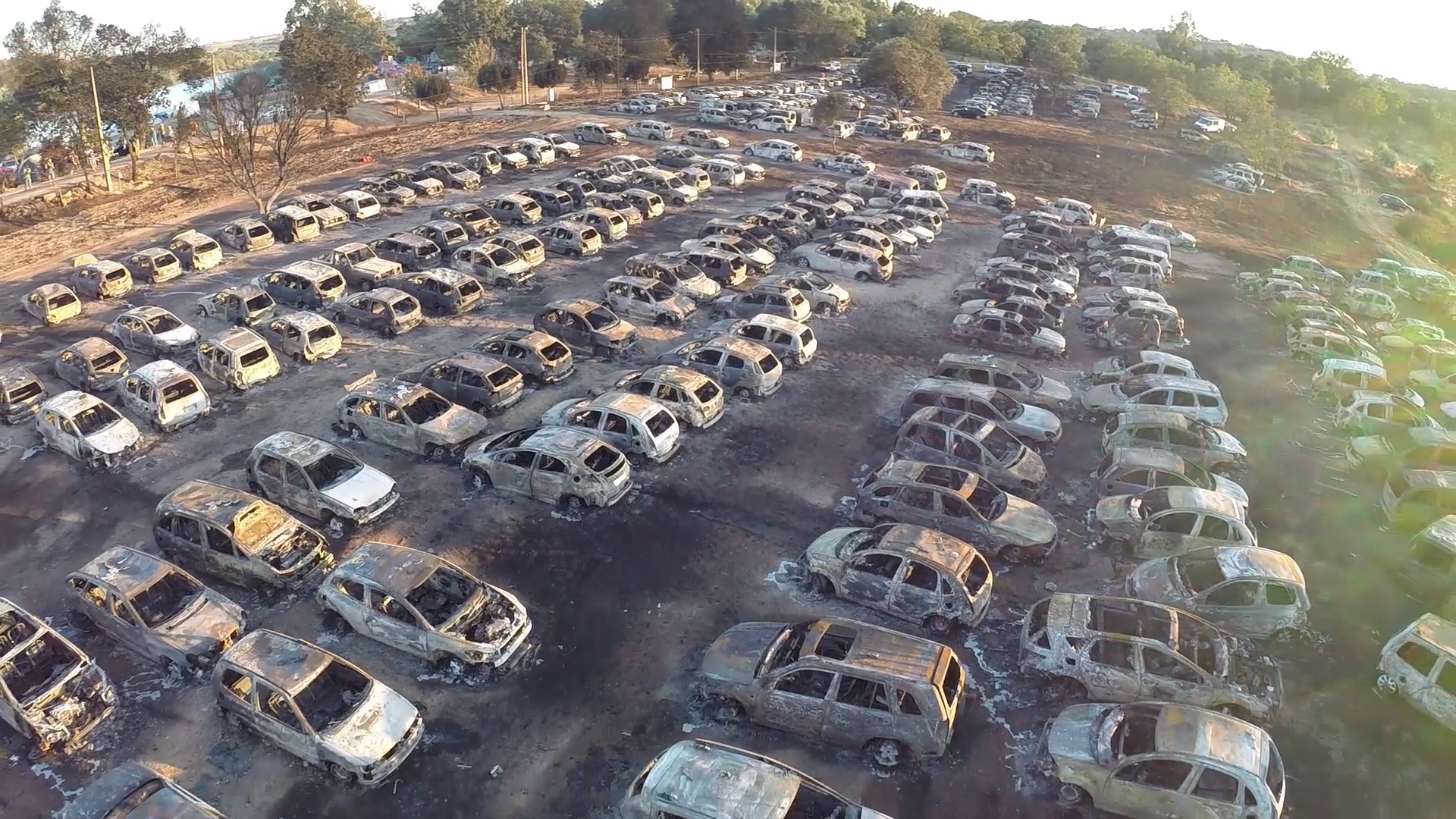 Стоянка разобранных машин. Сгоревшая стоянка машин. Сгоревшие дорогие машины. Горящая свалка автомобилей. Сгоревшая стоянка машин.